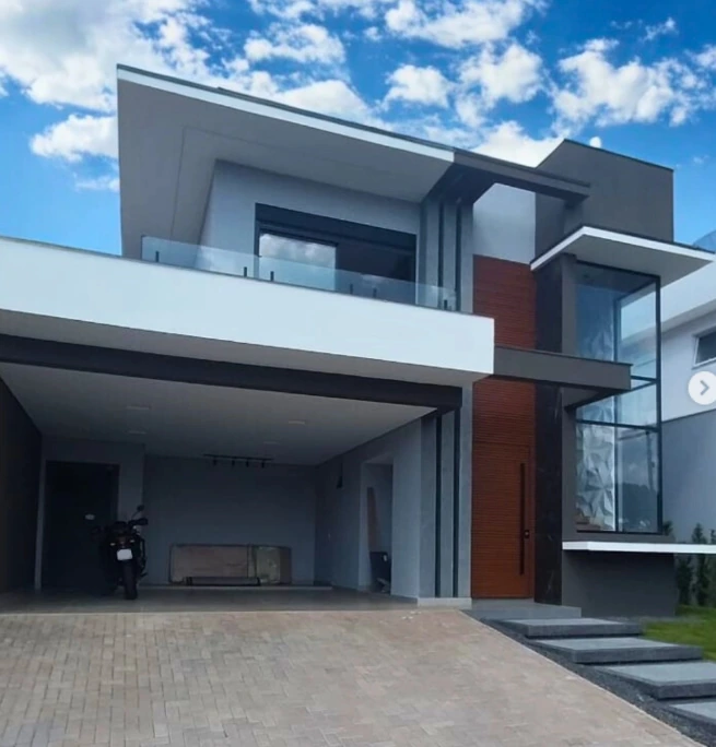 Fachada residencial contemporânea com esquadrias de alumínio pretas e grandes panos de vidro — projeto real Portal Prime